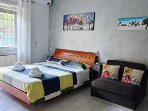 a bedroom with a bed and a chair at Casa Melo in Ciampino