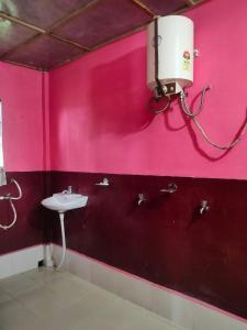 a bathroom with a pink wall with a sink at Hillside Highway Cottages in Shillong