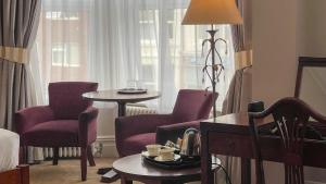 a hotel room with purple chairs and a table and a window at The Redstone Guesthouse in Blackpool