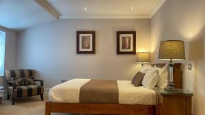 a bedroom with a bed with a lamp and a chair at The Redstone Guesthouse in Blackpool