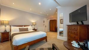 a bedroom with a large bed and a flat screen tv at The Redstone Guesthouse in Blackpool