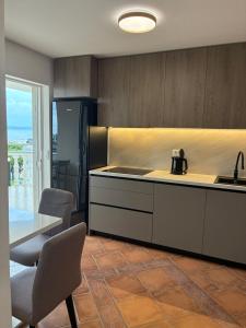 a kitchen with a counter and a table with chairs at Apartments Malic in Petrcane