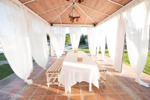 a table and chairs under a marquee with white drapes at Chalet las Pajanosas in Guillena