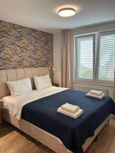 a bedroom with a bed with two towels on it at Apartments Malic in Petrcane