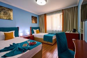 a hotel room with two beds and a table at Art Green Boutique Hotel in Varna City