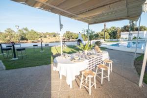 a table under a pavilion with a view of a pool at Chalet las Pajanosas in Guillena