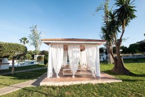 a gazebo in a park with a palm tree at Chalet las Pajanosas in Guillena