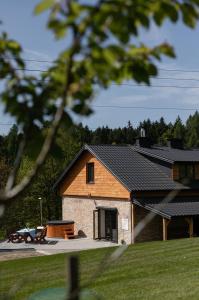 a house with a garage and a table at Domek Pod Strzegominą in Szerzyny