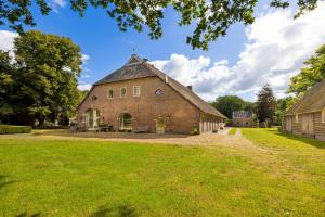 an old brick barn with a grass yard at Appartement Overcinge in Havelte