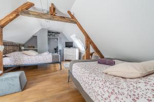 a bedroom with two beds in a attic at Gîte de la Cour in Campandré-Valcongrain