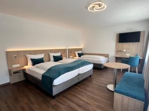 ein Hotelzimmer mit zwei Betten und einem Tisch in der Unterkunft Hotel Fantasie in Ansbach + 57 Fotos