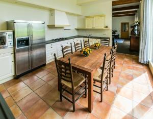 a kitchen with a wooden table with chairs and a refrigerator at Appartement Overcinge in Havelte