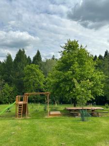 a park with a playground and a table and trees at Domek Pod Strzegominą in Szerzyny
