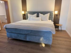 a bedroom with a large bed with blue and white sheets at Ferienwohnung im Sand in Herbolzheim