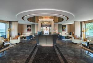 a hotel lobby with a woman standing at a counter at Azura Cruise in Ha Long