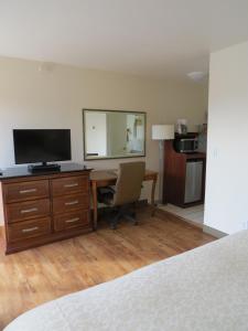 a bedroom with a desk with a television and a mirror at Laguna Lodge in Marina