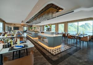 a restaurant with tables and chairs and windows at Azura Cruise in Ha Long