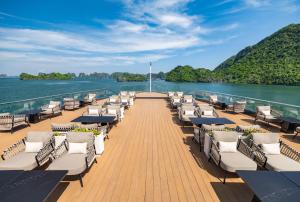 a deck of a boat with lounge chairs on the water at Azura Cruise in Ha Long