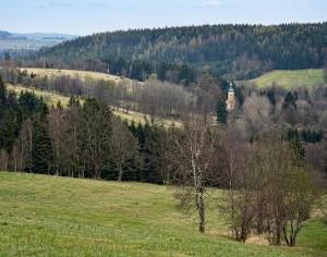 a green field with a castle in the distance at Zacisze nad Orlicą in Międzylesie +1 photo