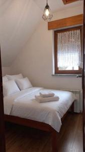 a bedroom with a bed with white sheets and a window at Zacisze nad Orlicą in Międzylesie