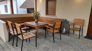a patio with a table and chairs and a bench at Zacisze nad Orlicą in Międzylesie
