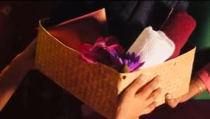 a person holding a box with a flower in it at Sattvic Ceylon- Wellness Homestay in Colombo