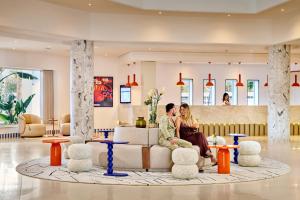 a man and woman sitting on a couch in a lobby at Houda Yasmine Marina & SPA in Hammamet