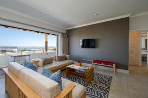 een woonkamer met een bank en een tv bij Harbour House Hotel - Harbour Square in Hermanus