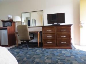 a hotel room with a desk with a television and a dresser at Laguna Lodge in Marina