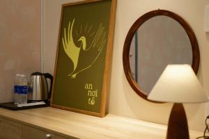 a mirror and a lamp on a counter with a picture of a bird at Tổ Homestay in Thôn Kim Long (1) +29 photos