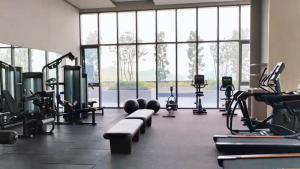 a gym with cardio equipment and a large window at 4BR Beachfront Pantai Cenang Langkawi in Pantai Cenang