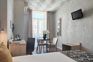 a hotel room with a table and a dining room at Hôtel Helvétique in Nice