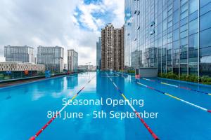 a large swimming pool in a city with tall buildings at ONESS Executive Hotel Guangzhou Huangpu - Free Shuttle Bus for Canton Fair during Canton Fair period in Guangzhou