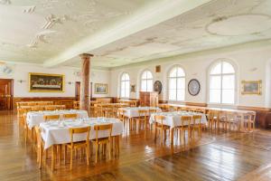 a dining room with white tables and chairs at Benediktinerstift Michaelbeuern in Michaelbeuern
