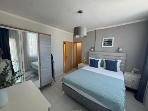 a bedroom with a large bed with blue pillows at Turtle Apartment Sunny Beach in Sunny Beach