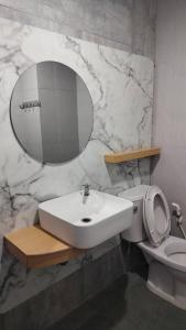 a bathroom with a sink and a toilet and a mirror at The City in Ban Si Than