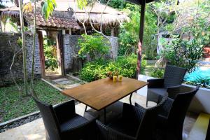 a wooden table and chairs on a patio at Pondok Ijo Villa in Yogyakarta