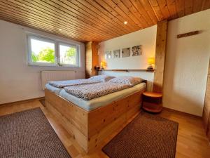 a bed in a room with a wooden ceiling at Damshagen Küstenkomfort in Damshagen
