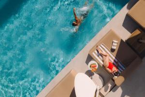 a man swimming in the water in a swimming pool at Saint Santorini in Oia