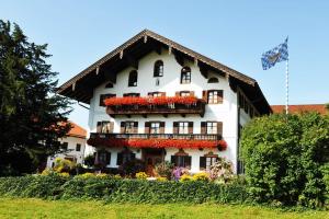 a large white building with flowers on it at Schneiderhof in Rimsting