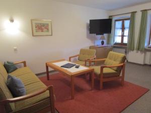 a living room with a table and chairs and a tv at Schneiderhof in Rimsting