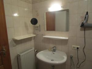 a small bathroom with a sink and a mirror at Schneiderhof in Rimsting +5 photos