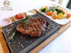 a plate of meat and vegetables on a table at Hotel Wellness & Spa Nowy Dwór in Rzeszów