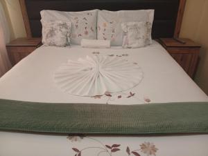 a white bed with a white umbrella on it at WilN Apartments in Francistown