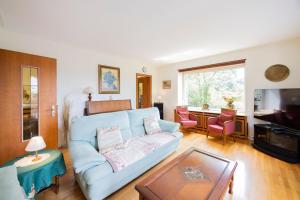 a living room with a blue couch and a table at Maison Bellevue in Brunstatt