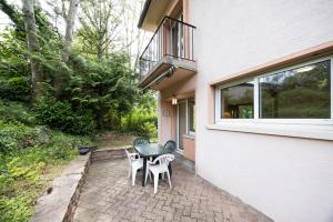 a patio with a table and chairs next to a building at Maison Bellevue in Brunstatt