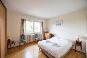 a bedroom with a bed and two chairs and a window at Maison Bellevue in Brunstatt