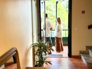 a man and a woman standing at the door at Hostal Finca La Oliva in Oleiros