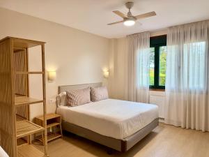 a bedroom with a bed and a ceiling fan at Hostal Finca La Oliva in Oleiros