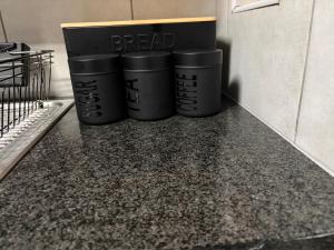 three black trash cans sitting on top of a counter at Malwandla 1bed full apartment in Centurion